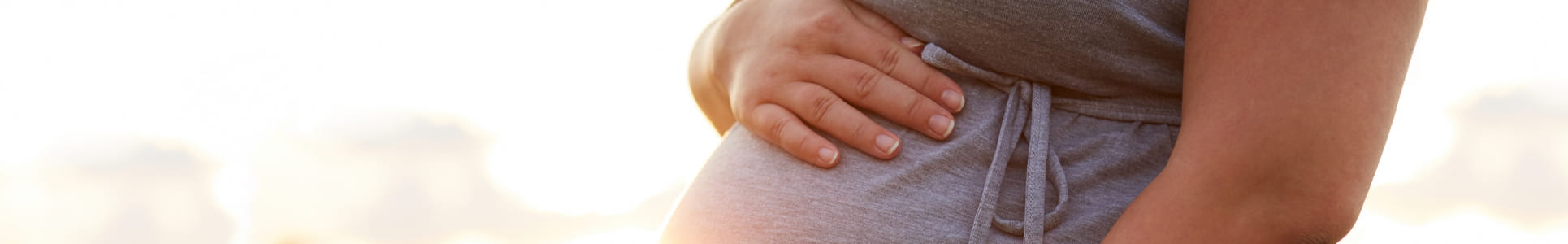 Close up of pregnant woman cradling her belly