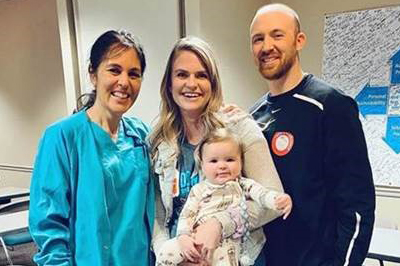 Kayleigh Summers (center) with her infant son, husband and one of the nurses at the blood drive