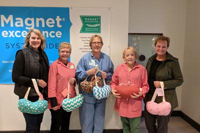GFWC Junior Women’s Club of Springfield members holding some of the donated hand-crafted comfort pillows