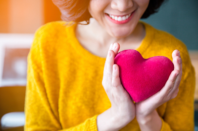 Woman holding plush red heart