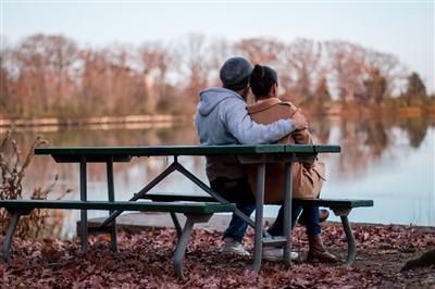 Couple comforting each other on park bench