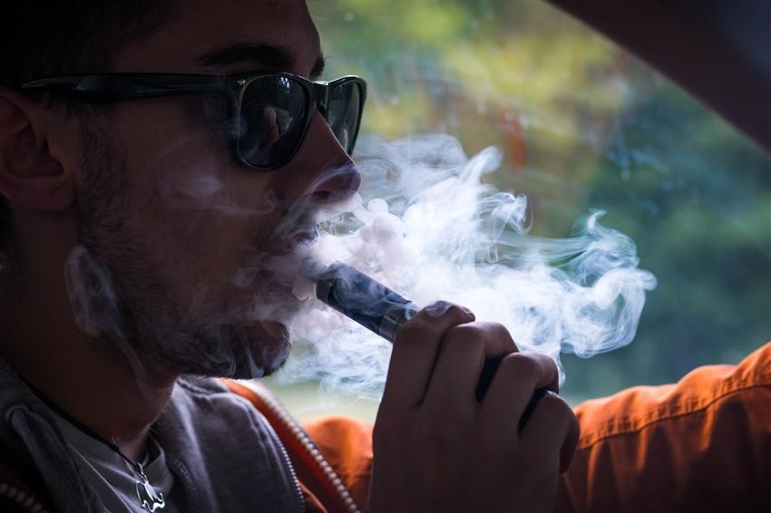 Young adult vaping while driving