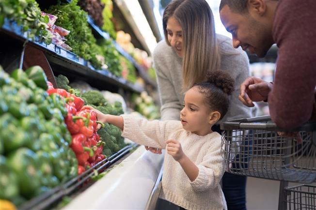 Family of three shopping in produce aisle