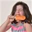 Child getting a brain freeze while biting and orange creamsicle Popsicle