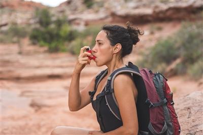 Person using inhaler while hiking