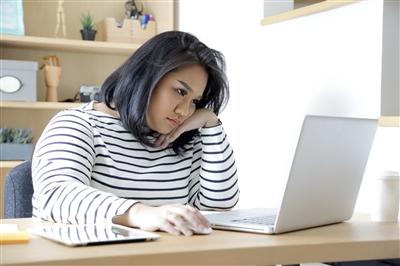 Woman working on computer looking sad