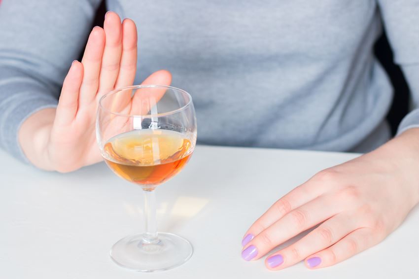 Close up on person refusing an alcoholic drink with a hand signal