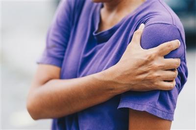 Woman clutching shoulder in pain