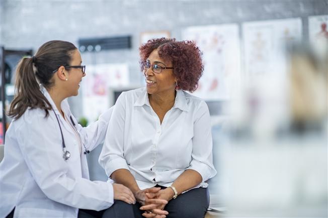 Woman talking to physician about clinical trials