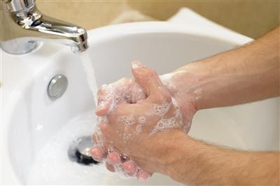 Close up on person washing their hands in the sink
