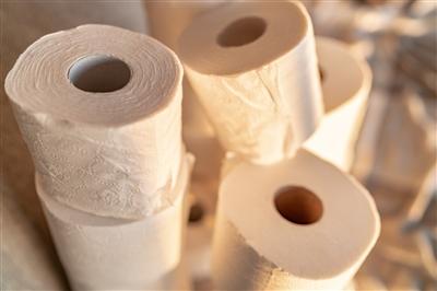 Photo of toilet paper stacked high and toppling over