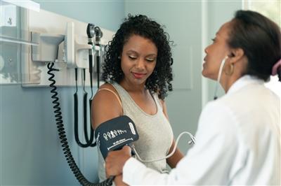 Woman getting blood pressure screened