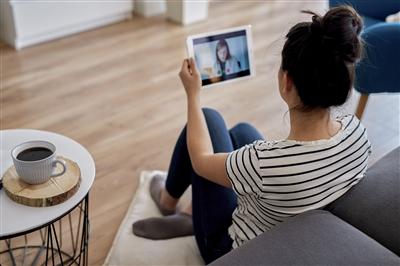 Young woman having virtual appointment with doctor to discuss physical symptoms of stress