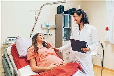 Female OBGYN talking to pregnant patient in office
