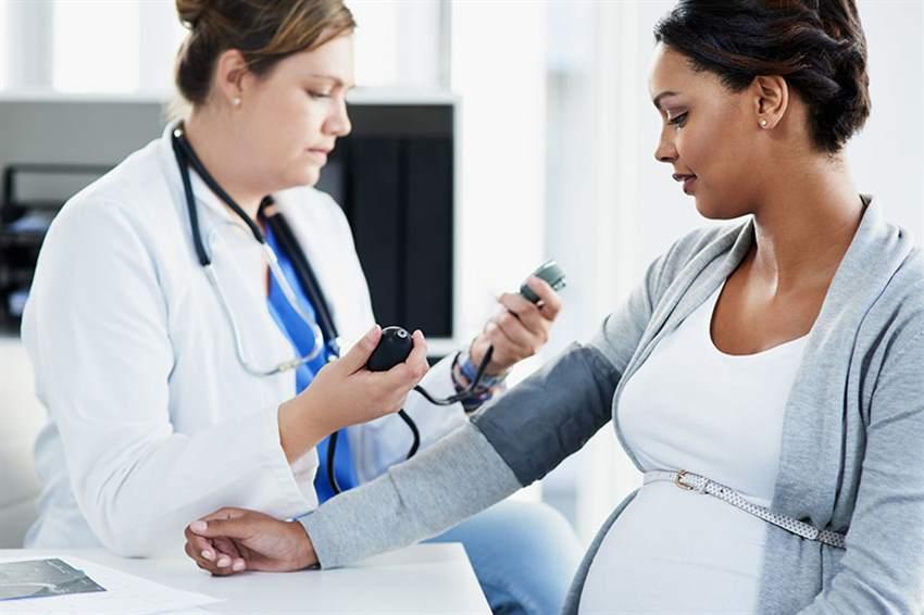 pregnant woman getting blood pressure checked