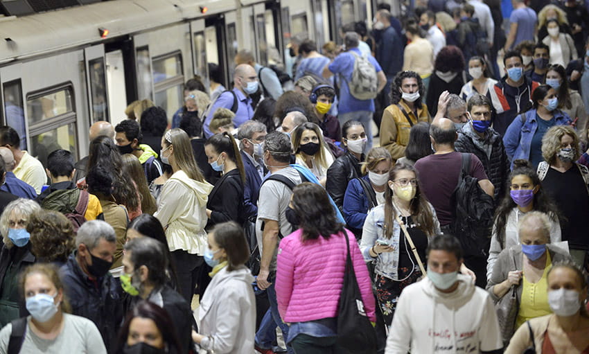 Busy subway station with people wearing masks
