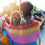 rainbow flag draped over young female couple
