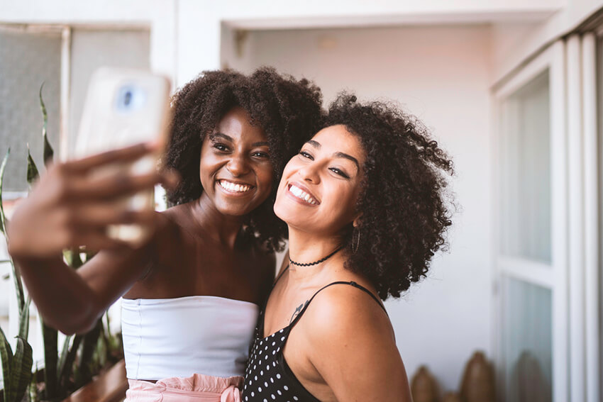 Two young women smiling and taking a selfie together.