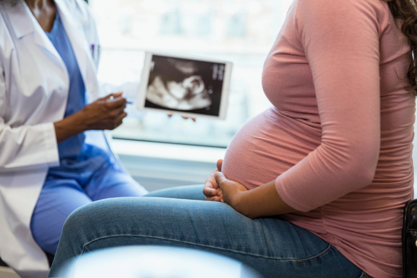 Pregnant woman and doctor looking at ultrasound.
