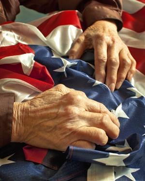 Older hands on an American flag