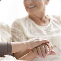 Caregiver holding hand of smiling patient