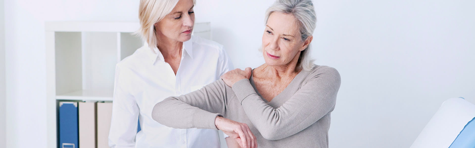 women touching shoulder in pain