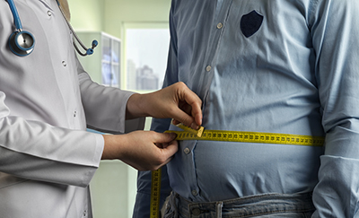 Doctor examine person's waist measure with tape