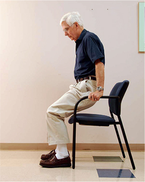 Demonstrating technique for getting out of a chair with arms