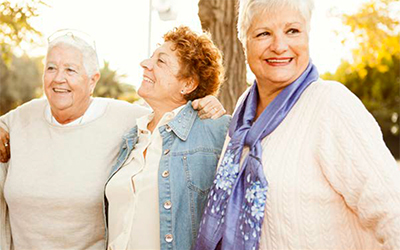 Three older woman smiling and enjoy outside